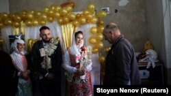 Pengantin Muslim Bulgaria Kimile Avdinova dan pengantin prianya Kadri Kichukov menyambut tamu selama upacara pernikahan mereka di Desa Ribnovo, di Pegunungan Rhodope, Bulgaria, 2 Januari 2022. (Foto: REUTERS/Stoyan Nenov)