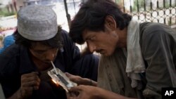 FILE - Pakistani drug addicts inhale drug smoke in Rawalpindi, Pakistan.