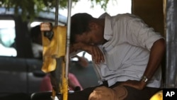 지난 25일 인도 하이데라바드에서 이력거를 끄는 남성이 더위를 피해 쉬고 있다.