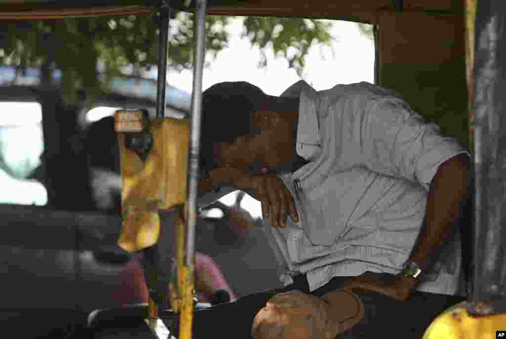 Seorang tukang becak beristirahat di tengah gelombang panas yang parah di Hyderabad, India (25/5). ​(AP/Mahesh Kumar A.)