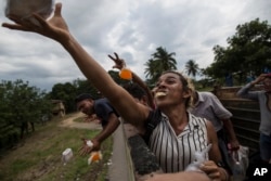 Teresa Perez, transgender asal Honduras, anggota sebuah kelompok LGBTQ yang bergabung dalam kafilah migran Amerika Latin yang menuju perbatasan AS, menangkap roti yang dilemparkan seorang penduduk, 2 November 2018.