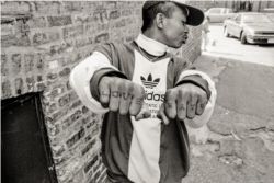 Another Cambodian Ricky shows the tattoos on his hands in a back alley of an apartment complex in Uptown, Chicago.