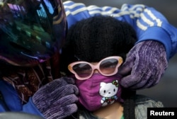 A mother adjusts her daughter's mask to help protect from worsening haze across northern Indonesia, neighboring Singapore and parts of Malaysia, in Kertapati district in Palembang, on the Indonesian island of Sumatra, Sept. 18, 2015.