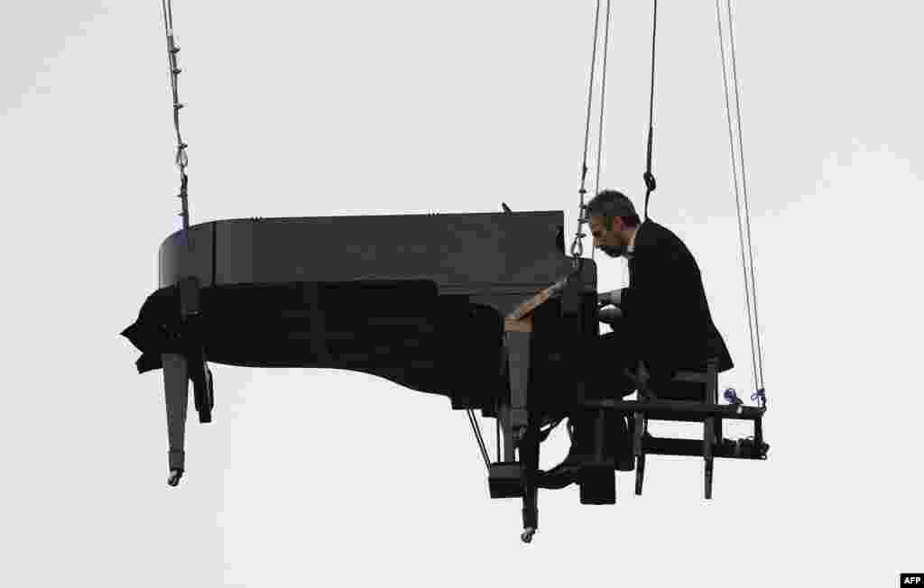 Brazilian pianist Ricardo de Castro Monteiro performs in the air at a piano hanging from wires, during the annual "Virada Cultural" event, in Sao Paulo, Brazil, June 21, 2015.