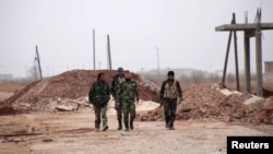 Forces loyal to Syria President Bashar al-Assad walk in the town of Tel Arn in Aleppo after capturing it from rebels Nov. 12, 2013. 