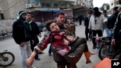  In this Sunday, March 11, 2012 file photo, a man carries a boy who was severely wounded during heavy fighting between Syrian rebels and Syrian Army forces in Idlib, north Syria. 