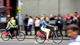 FILE - Commuters cycle past a bus stop outside Waterloo Station in London, Britain August 6, 2015.