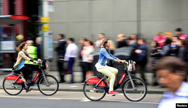 FILE - Commuters cycle past a bus stop outside Waterloo Station in London, Britain August 6, 2015.