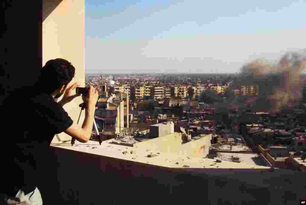 In this citizen journalism image provided by Shaam News Network, a Syrian citizen journalist documents Syrian forces shelling in Homs, Syria, July 24, 2012.