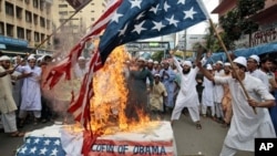 孟加拉的游行示威者们焚烧美国国旗