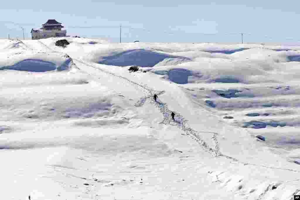 Palestinians walk on snow to reach their homes in the West Bank city of Nablus.