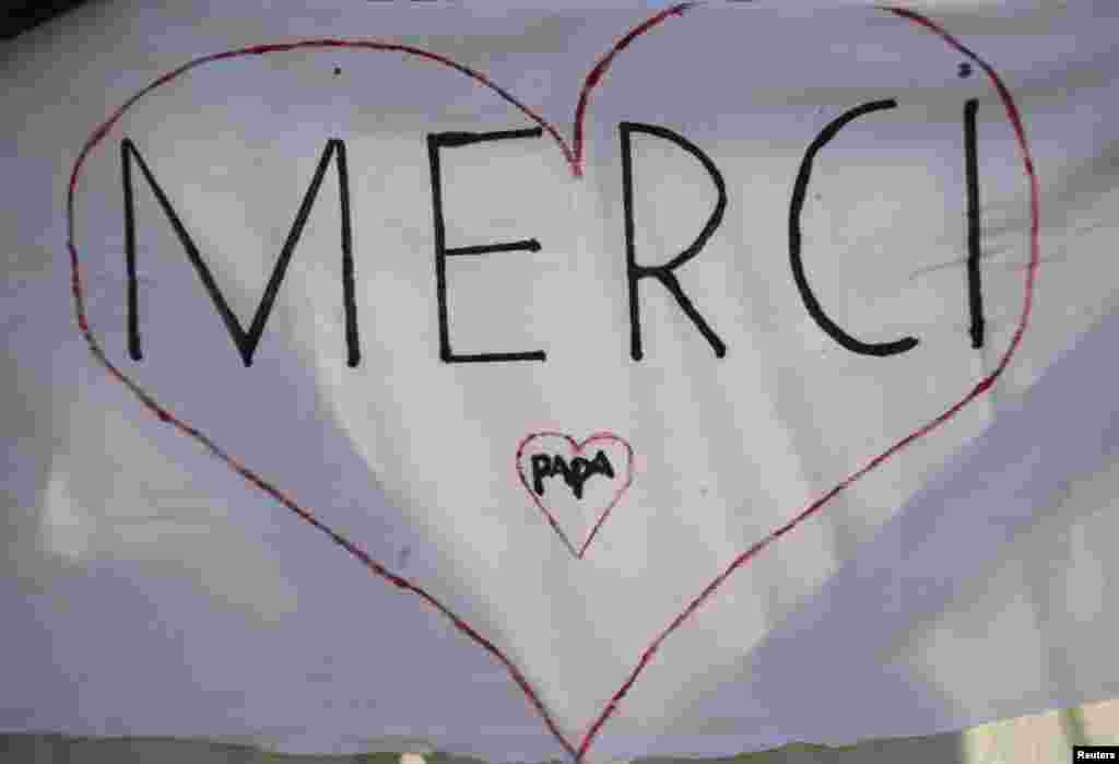 A sign reading "Thank you, Pope" in French is seen in St Peter's Square as Pope Benedict XVI holds his last general audience at the Vatican Feb. 27, 2013.