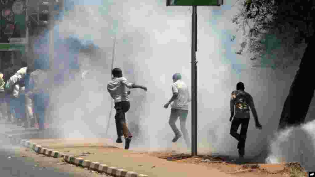 University students run as police use tear gas to disperse them during a demonstration in Nairobi, Kenya, Tuesday, Sept, 22, 2015. 