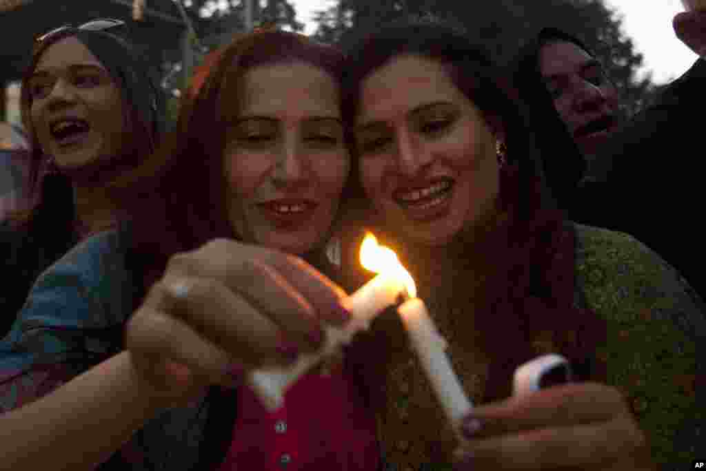 Para transgender di Pakistan menyalakan lilin dalam demonstrasi oleh kelompok masyarakat madani untuk memperingati Hari AIDS Sedunia di Karachi (1/12). (AP/Shakil Adil)