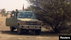 FILE - Fighters from the Tuareg separatist rebel group MNLA take shade under a tree in the desert near Tabankort, Mali, Feb. 15, 2015. 