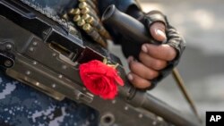 A Taliban fighter with a rose on his machine gun secures an area in Kabul, Afghanistan, Dec. 4, 2021.