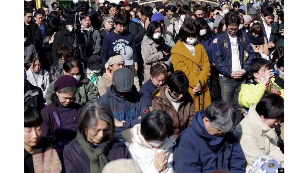 People mourn the victims of the March 11, 2011, earthquake and tsunami during a special memorial event in Tokyo, March 11, 2017.