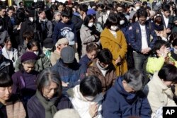 People mourn the victims of the March 11, 2011, earthquake and tsunami during a special memorial event in Tokyo, March 11, 2017.