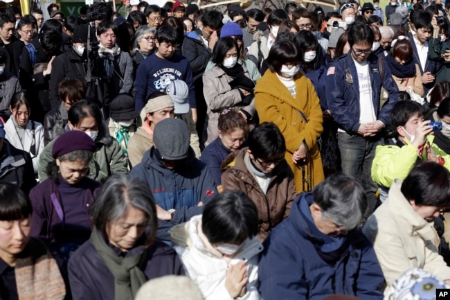 People mourn the victims of the March 11, 2011, earthquake and tsunami during a special memorial event in Tokyo, March 11, 2017.