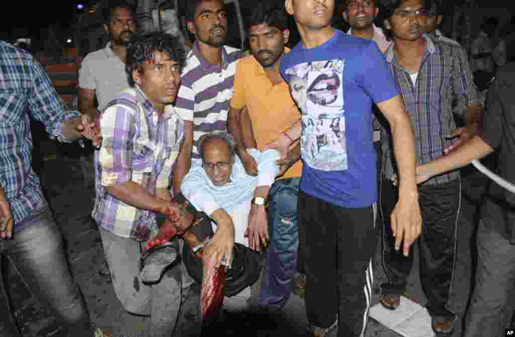 People rescue an injured person after a bomb blast in Hyderabad, India, February 21, 2013.
