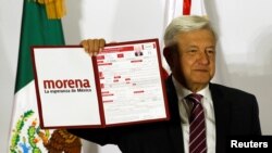 Mexican presidential candidate Andres Manuel Lopez Obrador of the National Regeneration Movement (MORENA), shows a document during his registration for the July 2018 presidential election, in Mexico City, Dec. 12, 2017