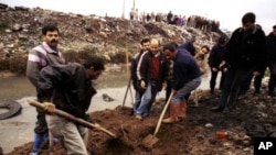 Plainclothes policemen and workers recover the remains of a missing person killed by radical islamic guerrillas, from a site in the southern Turkish city of Adana (File Photo)