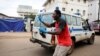 Un homme oriente les ambulances à leur arrivée à l'entrée de l'hôpital Connaught à Freetown, en Sierra Leone, le 16 août 2017.