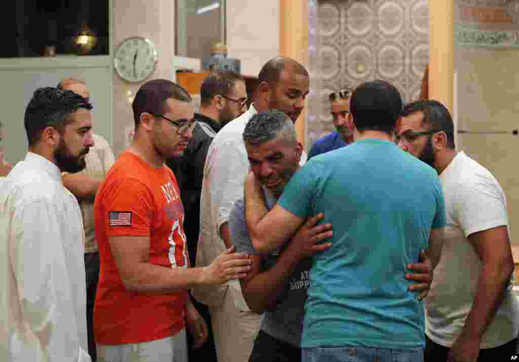 Tahar, center, the father of Kylan Mejri, a 4-year-old boy who killed in Thursday's truck attack, is comforted by relatives at the ar-Rahma mosque in the eastern Nice suburb of Arian, France. Tahar's wife Olfa Kalfallah, 31, was also killed.