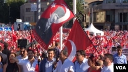 Demonstrators at Taksim Square wave flags bearing the face of Mustafa Kemal Ataturk, revered as founder of the modern Turkish Republic, July 24, 2016. Many are calling for preservation of the secular state established by Ataturk nearly a century ago. (L. Ramirez/VOA)