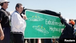 An April 18, 1996 file phoso shows a Nevada Governor Bob Miller (C), presiding over the unveiling of a new road sign for Nevada State Highway 375, the site for many UFO sightings, in Rachel, north of Las Vegas.