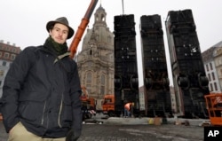 Syrian artist Manaf Halbouni poses in front of three busses close to the 'Frauenkirche' church in the center of the east German city of Dresden, Germany, Feb. 6, 2017.