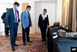Afghan Ambassador to the U.S. Roya Rahmani, right, accompanied by embassy staff, speaks as she gives the Associated Press a tour at the Afghanistan Embassy in Washington, Wednesday, April 21, 2021