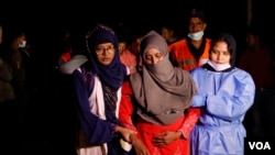 Officials help a survivor to safety after a boat filled with Rohingya refugees capsized at St. Martin's Island, Bangladesh, Tuesday, Feb. 11, 2020. (Hai Do/VOA)