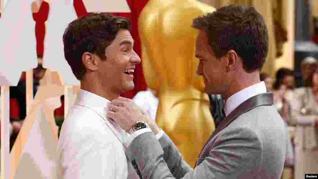 L&#39;hôte des Oscars,&nbsp;Neil Patrick Harris, ajuste la cravate de son mari David Burtka (G) à leur arrivée à la cérémonie des 87e Oscars à Hollywood, Californie, le 22 février 2015.
