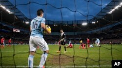 Pemain Manchester City, Sergio Aguero mengambil bola dari net setelah sebuah gol dari kawan satu timnya Yaya Toure dalam pertandingan dengan Cardiff City, Januari. (AP/Jon Super)