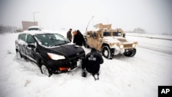 Binh sĩ và lính cứu hỏa trên chiếc Humvee giúp một người lái xe bị mắc kẹt trong tuyết trên đường I-395 tại Washington. 