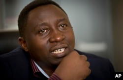 FILE - Frank Habineza speaks to a reporter at his offices in Kigali, Rwanda, March 25, 2014.