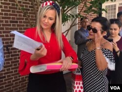 Kelly Oliveira examines paperwork before her naturalization ceremony in Baltimore, Maryland. (Photo: A. Barros / VOA)