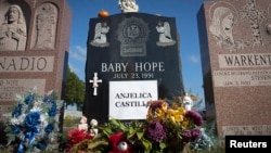 FILE - The tombstone of Anjelica "Baby Hope" Castillo, whose body was found crammed in a picnic cooler in 1991, is seen in the Bronx borough of New York, Oct. 13, 2013. 