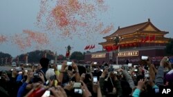 중국 건국 65주년을 맞은 1일 베이징 톈안먼 광장에서 국기게양식에 이어 축하 풍선을 날려보냈다. 참석자들이 스마트폰으로 기념식 장면을 담고 있다.