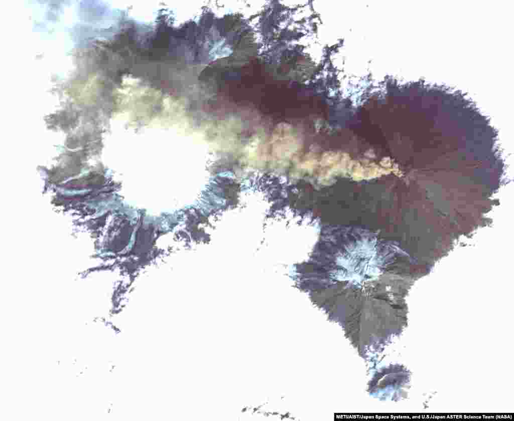 Shiveluch, one of the world&#39;s most active volcanoes, is seen poking through a solid cloud deck, with an ash plume streaming to the west. Located on the Kamchatka Peninsula in far eastern Russia, it is one of many active volcanoes on the peninsula.