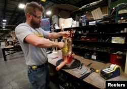 FILE - Joel Dykema works on the sub-assembly of a transformer in the RoMan Manufacturing plant in Grand Rapids, Mich., Dec. 12, 2018. A Federal Reserve report released Jan. 18, 2019, showed U.S. manufacturing output had surged by the most in 10 months in December 2018.