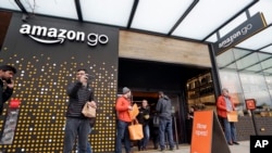 People stand outside an Amazon Go store Monday, Jan. 22, 2018, in Seattle. (AP Photo/Elaine Thompson)