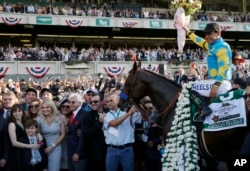 Victor Espinoza sits astride American Pharoah in the winner's circle after gliding to victory in the 147th running of the Belmont Stakes at Belmont Park in Elmont, N.Y., June 6, 2015.