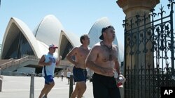 Lunch-time runners with their shirts off in the heat of the day pass through the old Botanical Gardens gates near the Sydney Opera House. Health authorities in Australia have appealed for a sense of vanity in an attempt to scare them into being more sun s