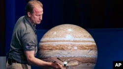 Rick Nybakken, responsable de Juno tient un modèle de l'orbite. Le voyage sur Jupiter, le 4 juillet 2016 (