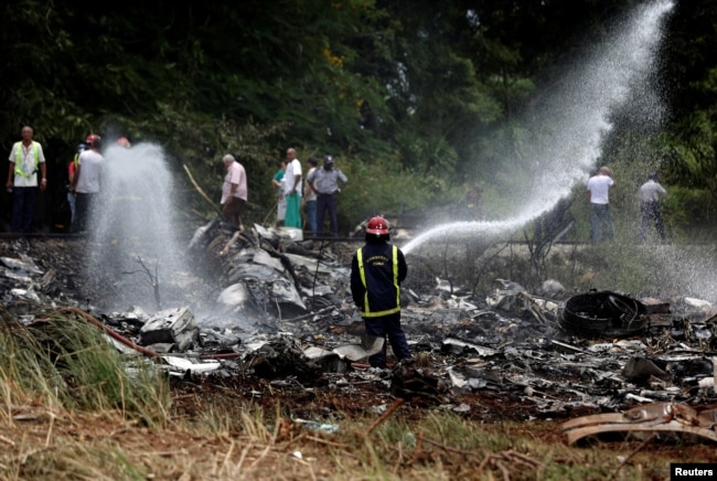 FILE - A firefighter works in the wreckage of a Boeing 737 plane that crashed in the agricultural area of Boyeros, south of Havana, shortly after taking off from Havana's main airport in Cuba, May 18, 2018.