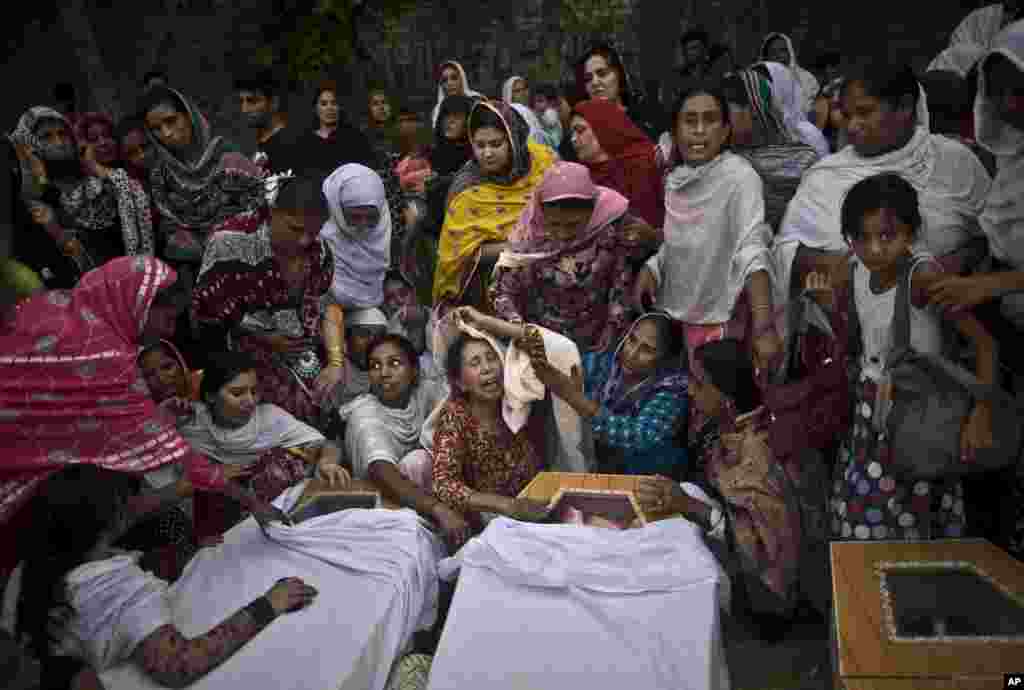 Women grieve over the coffins of their relatives, who were killed in a suicide attack on a church, in Peshawar, Pakistan, Sept. 22, 2013.