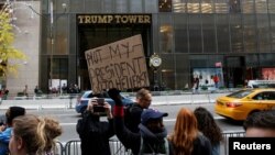 川普选举获胜后，一名妇女在纽约市川普大厦外举行抗议（2016年11月10日）