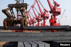 工人在江苏连云港把钢材装船出口（2013年6月4日）中国钢铁产能严重过剩